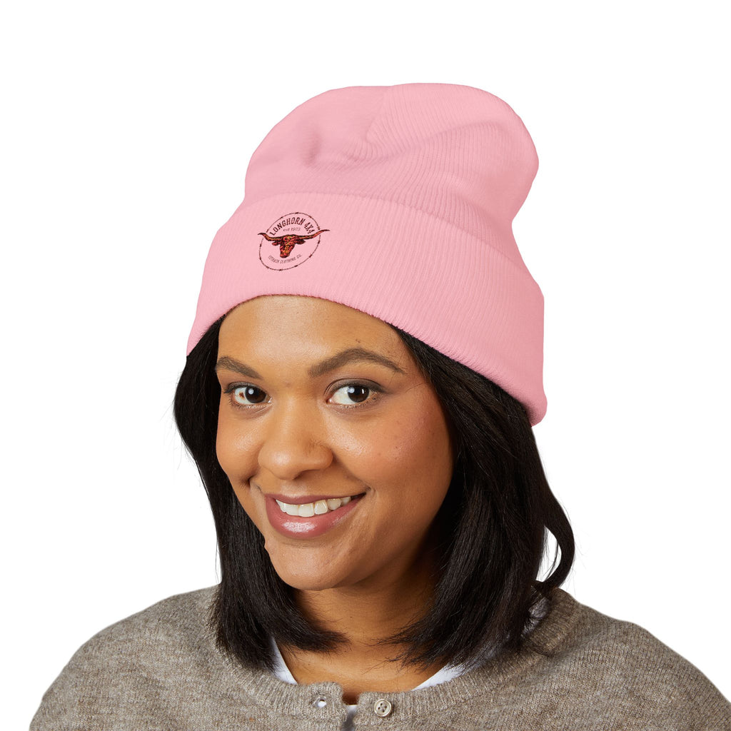 Person wearing a pink beanie with a logo on a white background