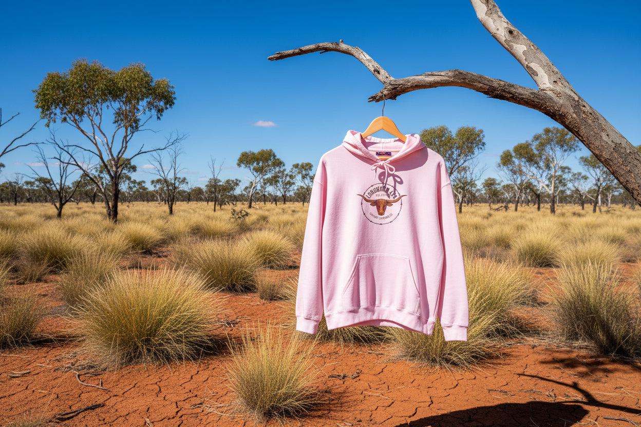 Pink hoodie with a logo hanging on a tree in the Australian outback background