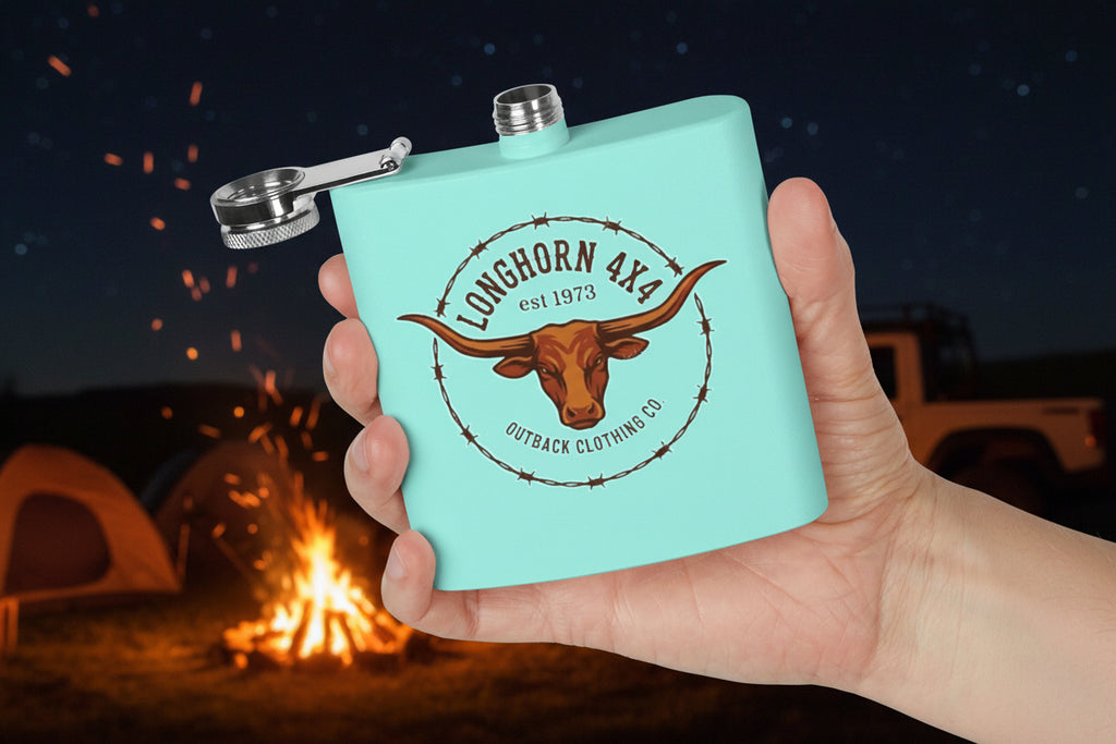 Light blue flask with longhorn design held in a hand against a camp fire background