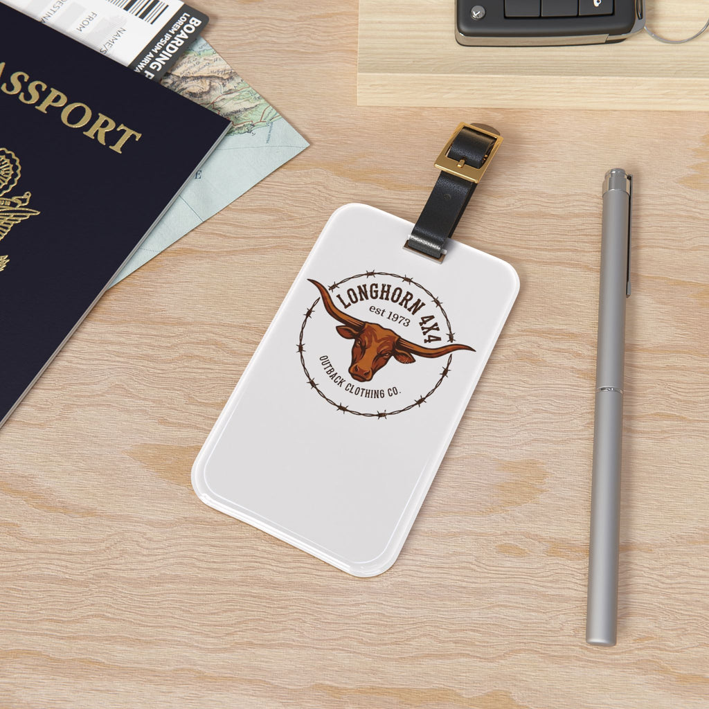 Luggage tag with a brand logo on a wooden surface with passport and pen.