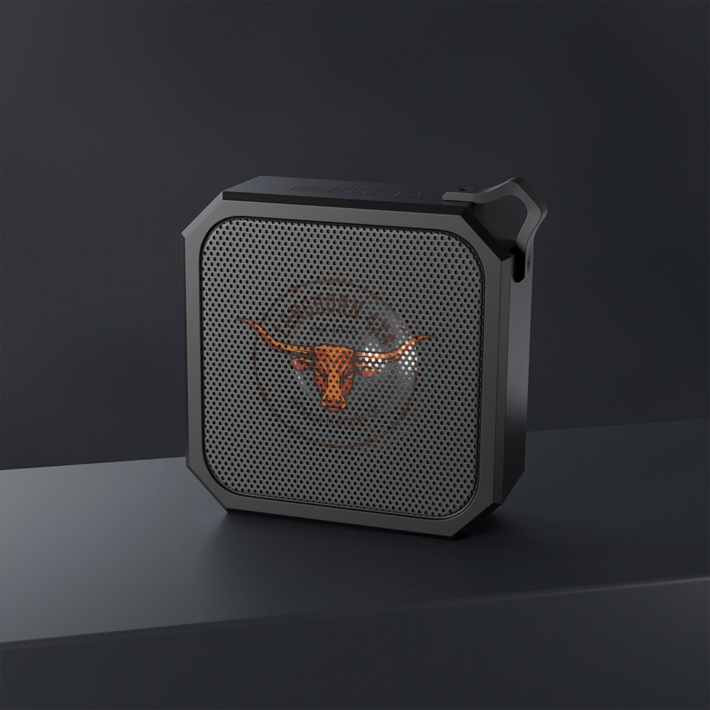 Black portable speaker with a logo on a dark background