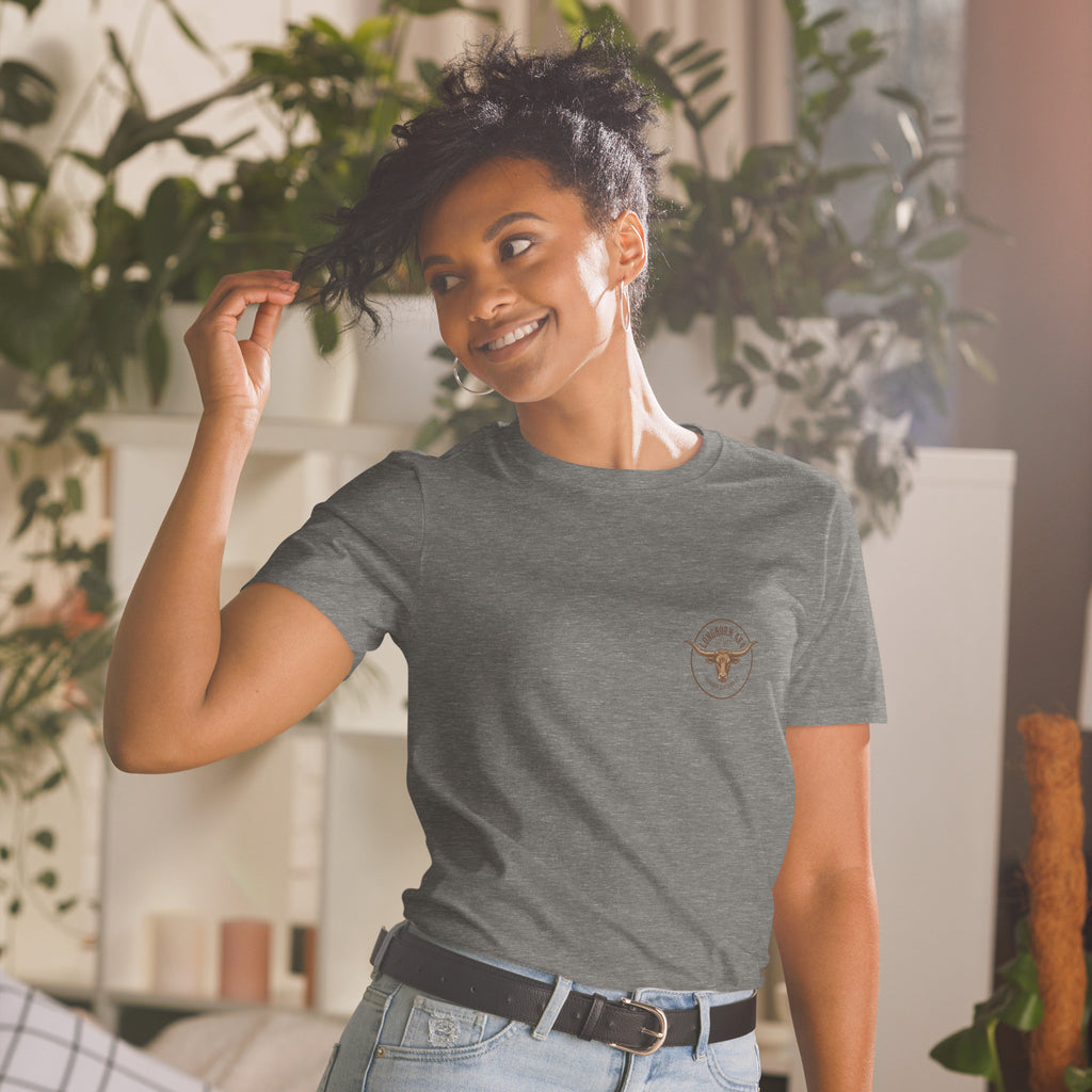 Girl Playing with her hair, wearing a longhorn 4x4 t-shirt with plants in the background. 