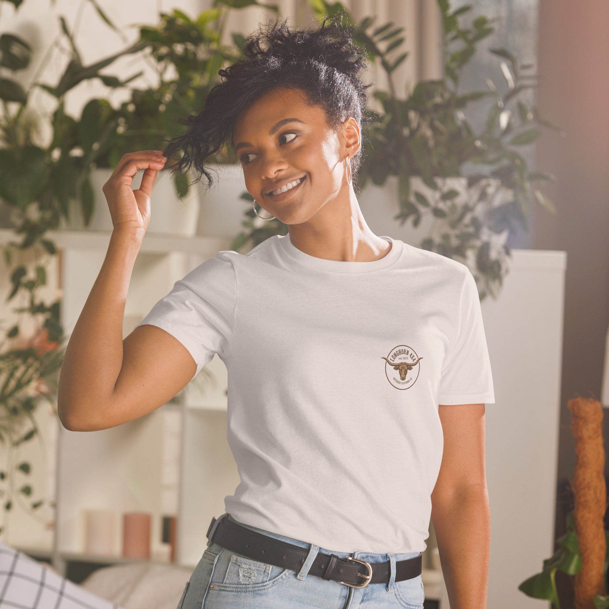 Woman wearing a white t-shirt with a logo in a casual setting with plants